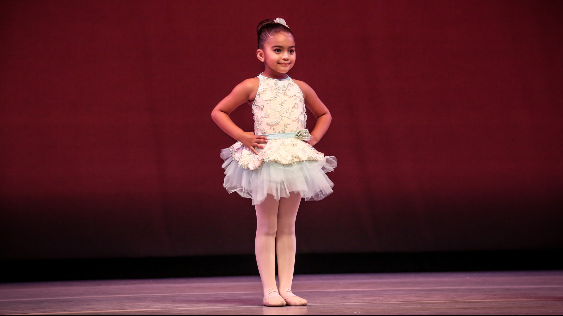 Ballet student standing on stage wearing a ballet tutu