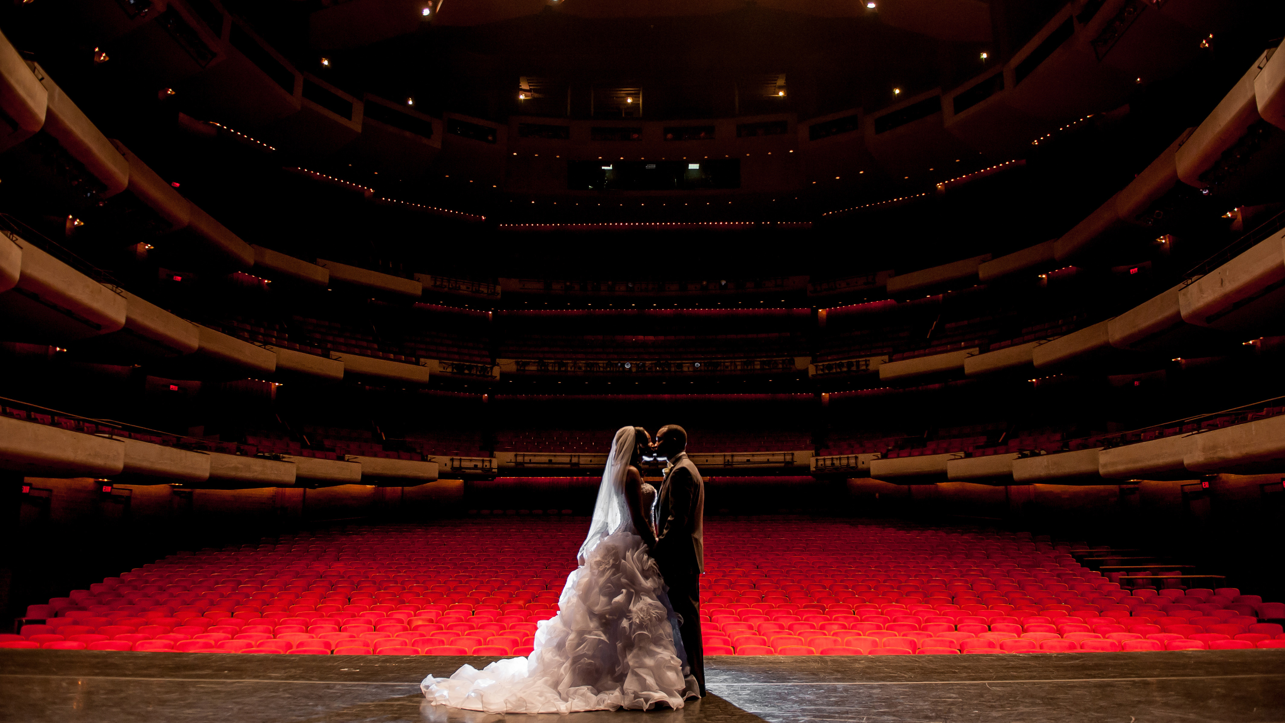 Wedding couple kissing on the Morsani Hall stage.