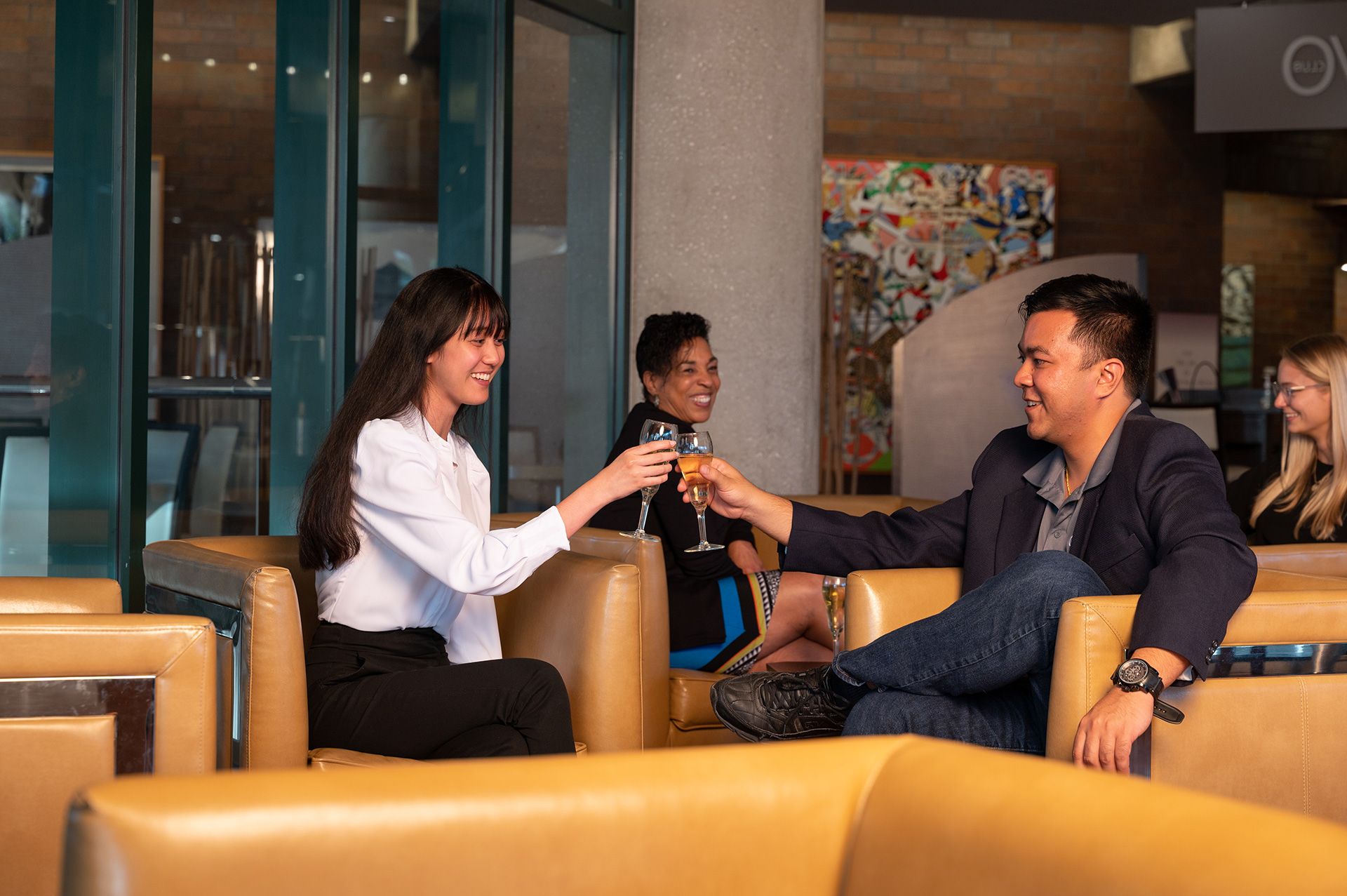 Friends sitting down and toasting each other at the Bravo club