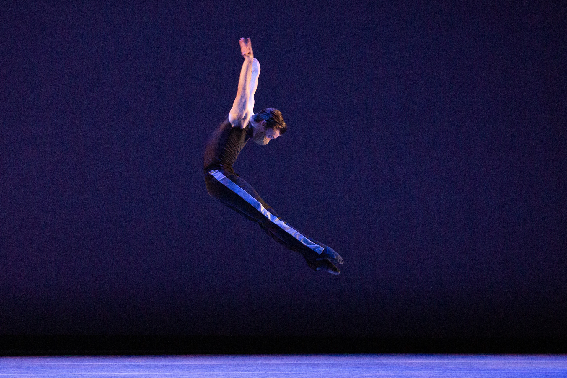NGB ballet student in midair jump on stage.