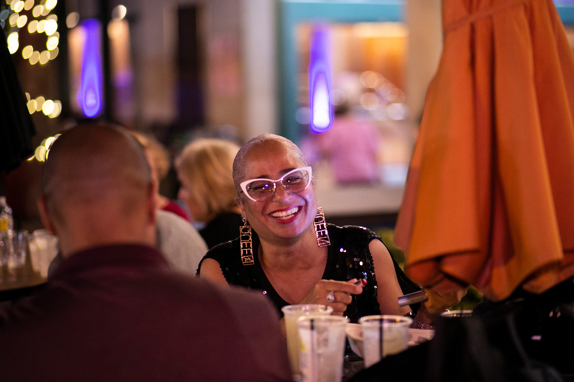 Patrons laughing together at a table on the Riverwalk.